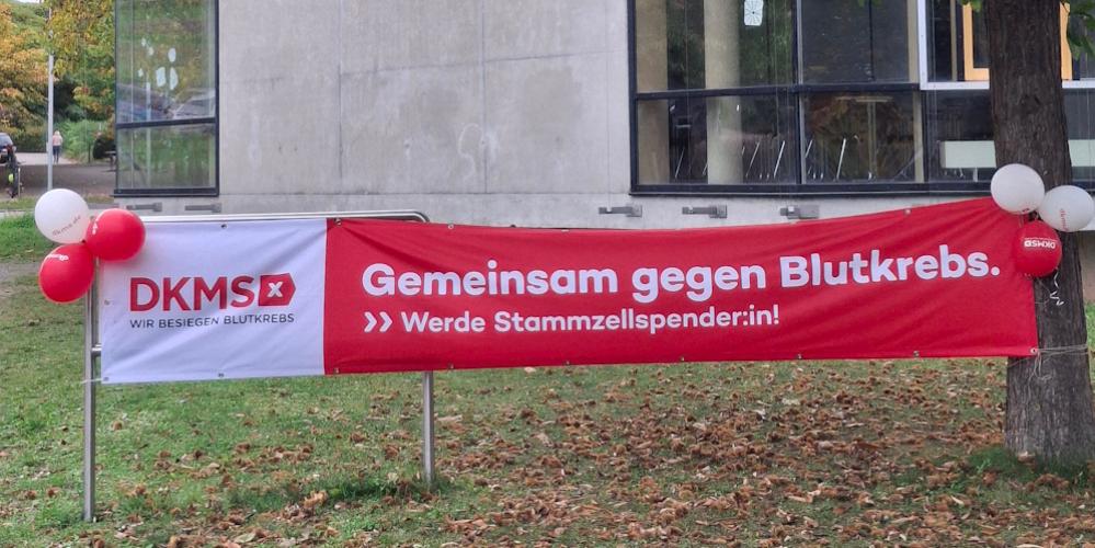 Ein rotes Banner mit der Aufschrift 'Gemeinsam gegen Blutkrebs' ist vor der Schule aufgespannt. (c) Frank Klemm Ein rotes Banner mit der Aufschrift 'Gemeinsam gegen Blutkrebs' ist vor der Schule aufgespannt.
