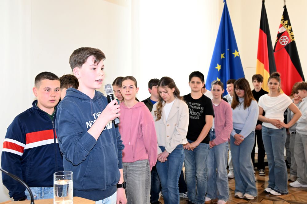 Die Schüler stehen in einer Reihe, damit jeder eine Strophe vortragen kann. (c) Staatskanzlei RLP / Schäfer Die Schüler stehen in einer Reihe, damit jeder eine Strophe vortragen kann.