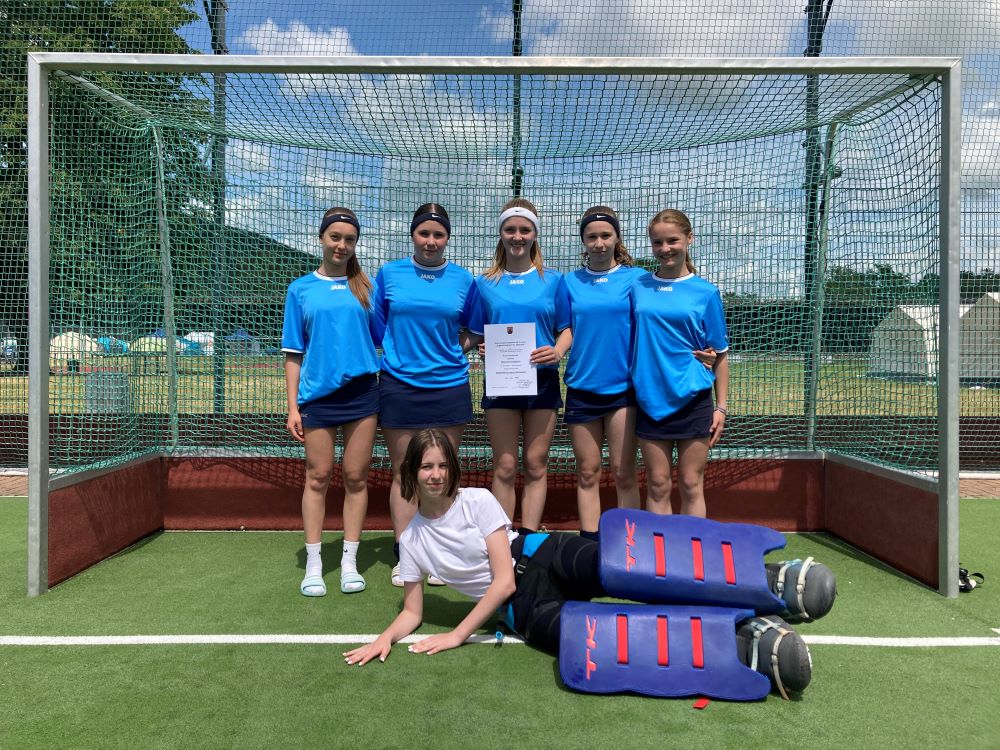 6 Mädchen stehen in einem Hockeytor