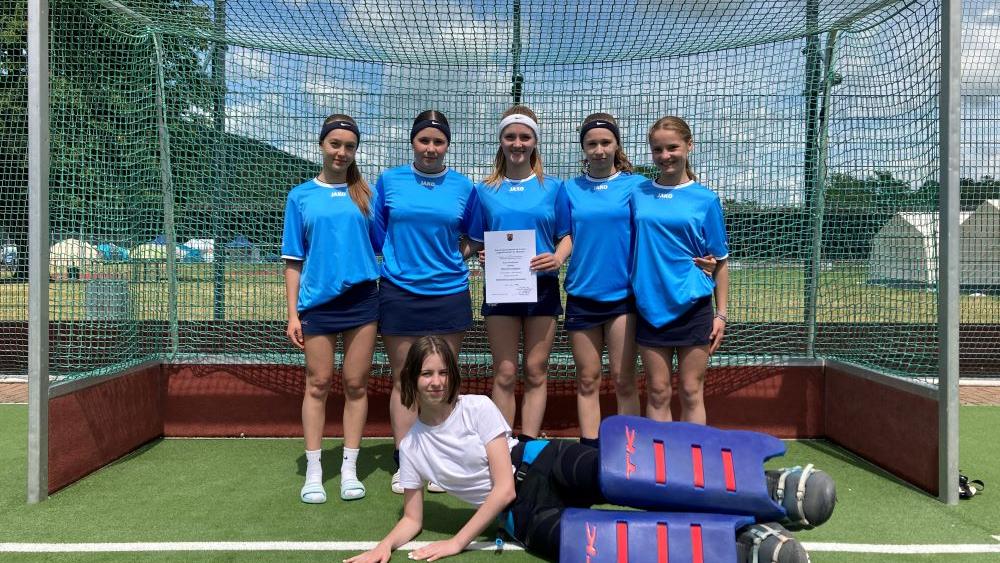 6 Mädchen stehen in einem Hockeytor