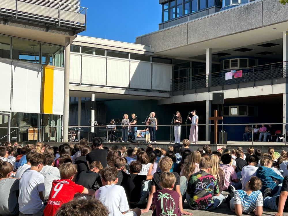 Schüler sitzen auf dem Schulhof und feiern Kahal.