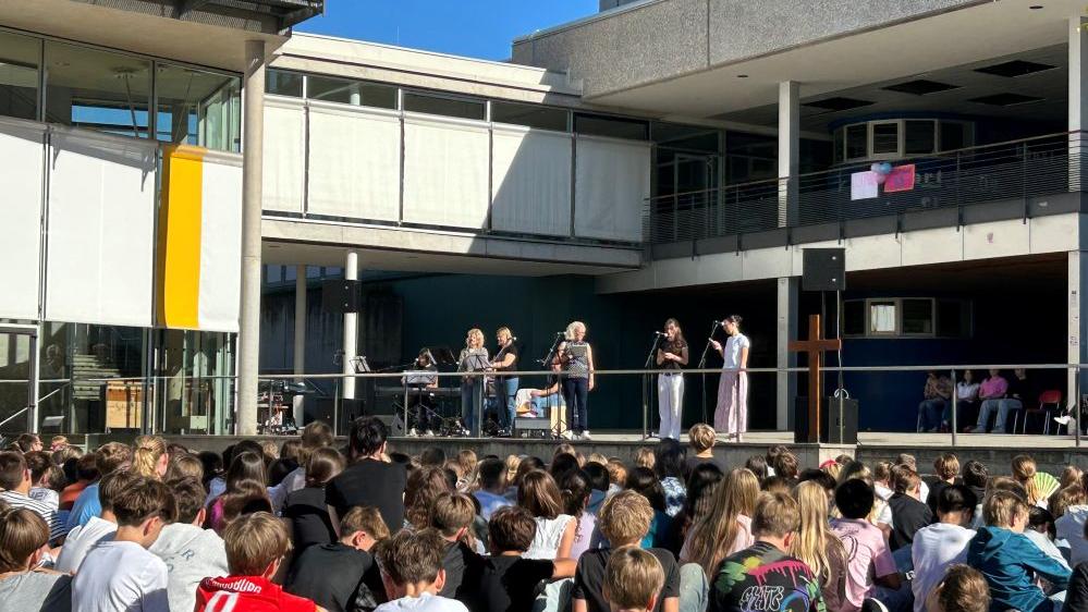 Schüler sitzen auf dem Schulhof und feiern Kahal.