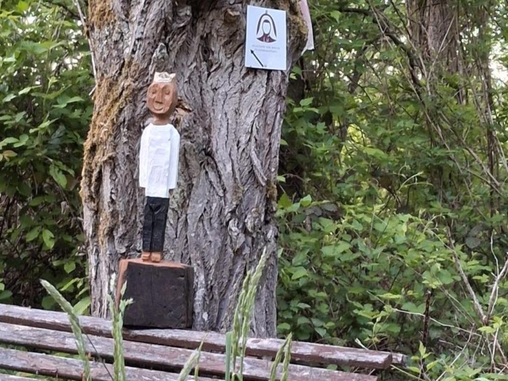 Königfigur auf einer Bank im Grünen