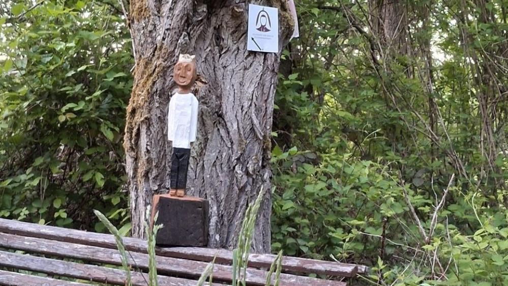 Königfigur auf einer Bank im Grünen