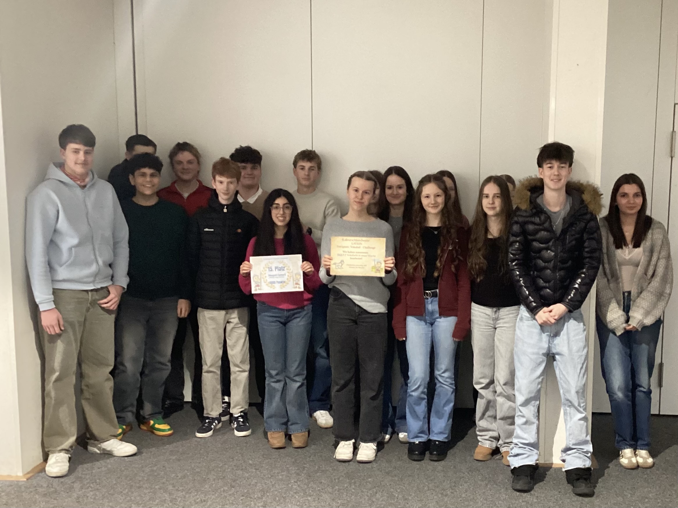 Eine Schülergruppe zeigt eine Urkunde mit dem erreichten Platz.