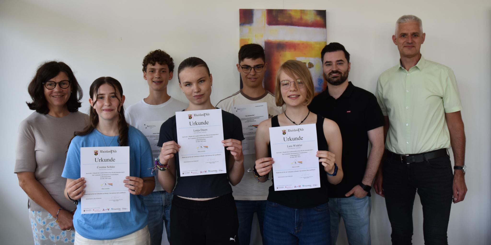 Fünf SchülerInnen präsentieren mit Stolz gemeinsam mit ihren LehrerInnen ihre Urkunden zum Physikwettbewerb (c) Claudia Römer Fünf SchülerInnen präsentieren mit Stolz gemeinsam mit ihren LehrerInnen ihre Urkunden zum Physikwettbewerb