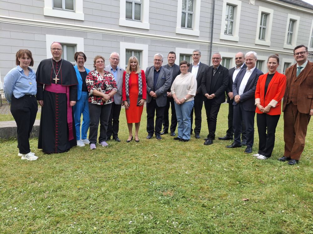Verantwortliche der Schulstiftung stehen im Garten vor dem Dommuseum.