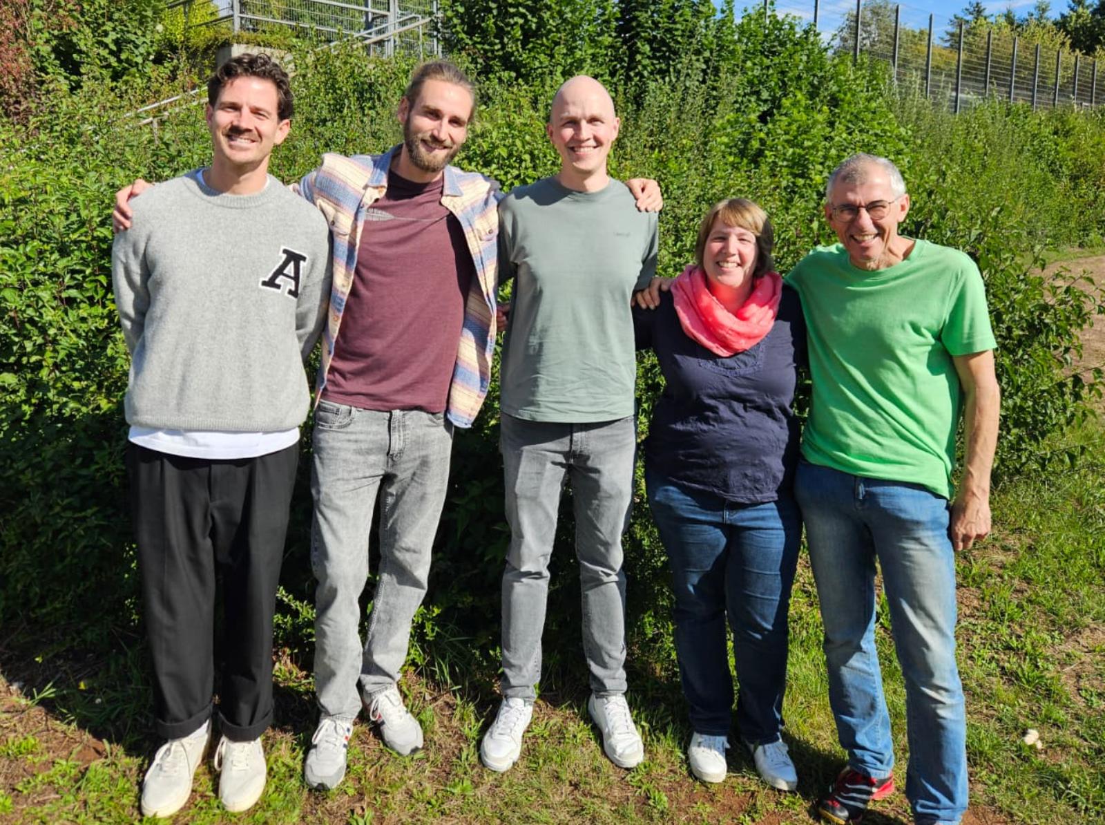 Die Vertrauenslehrkräfte stehen neben dem Sportplatz.