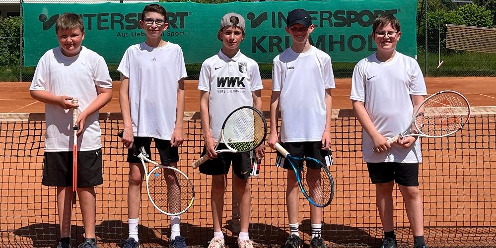 Fünf junge Tennisspieler stehen auf einem Tennisplatz.