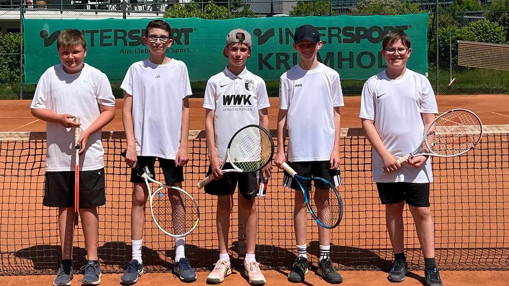 Fünf junge Tennisspieler stehen auf einem Tennisplatz.