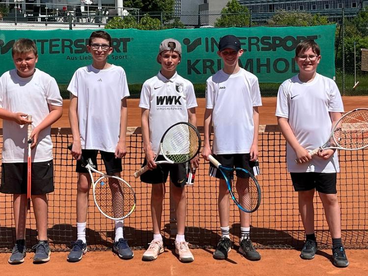 Fünf junge Tennisspieler stehen auf einem Tennisplatz.